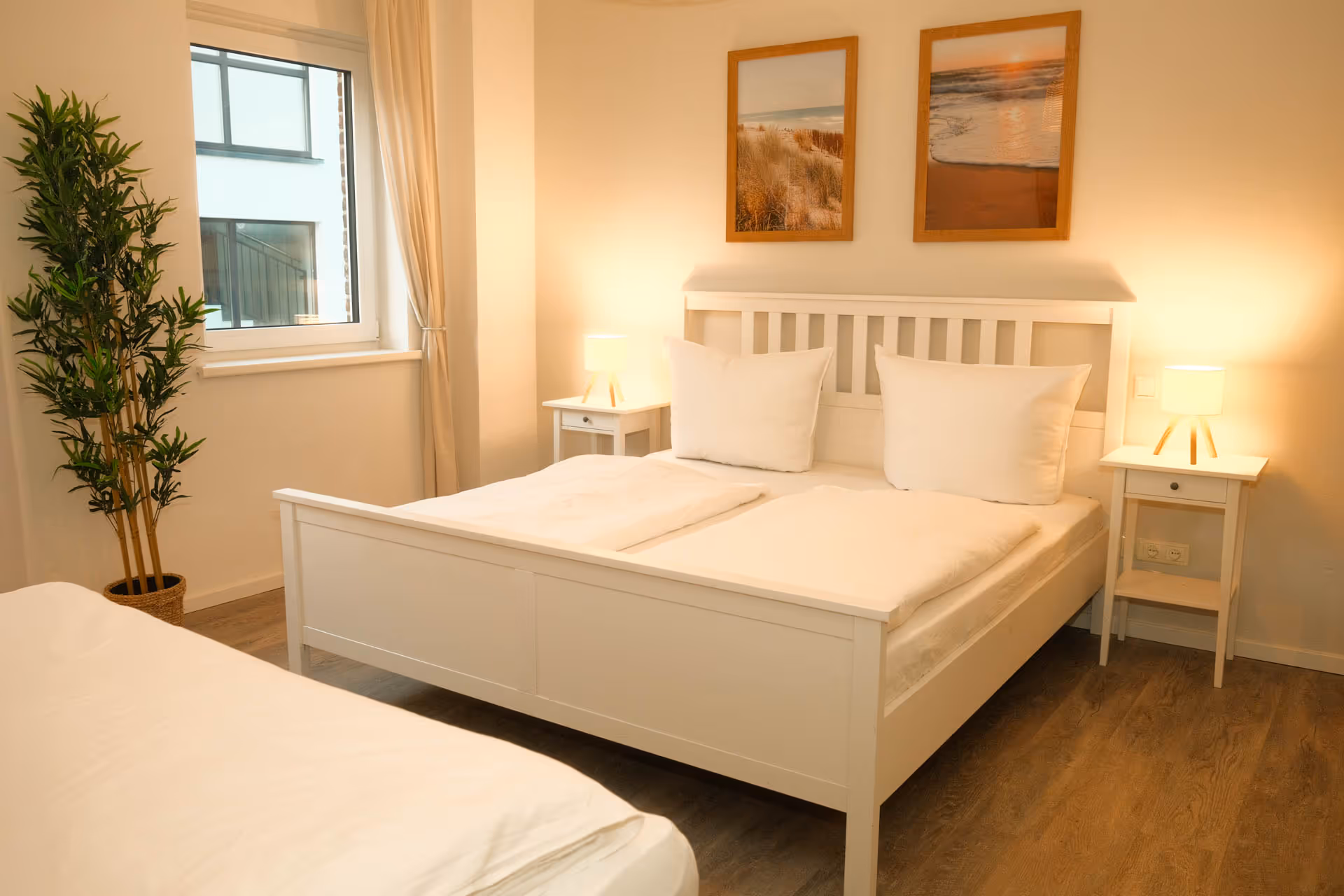 Doppelbett mit weißen Kissen und Nachttischen