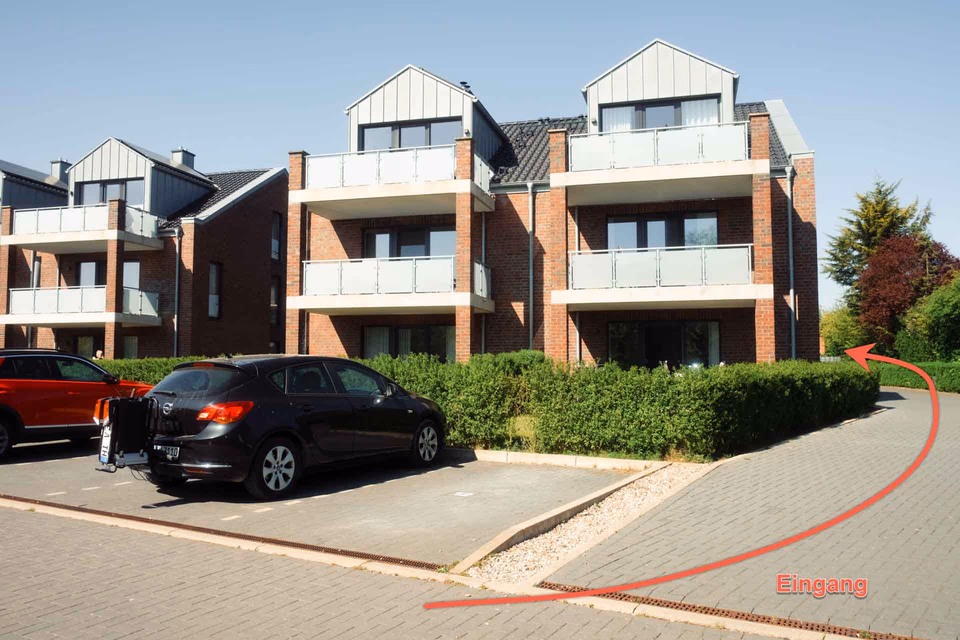 Wohnanlage mit Parkplatz und Blick zum Eingang