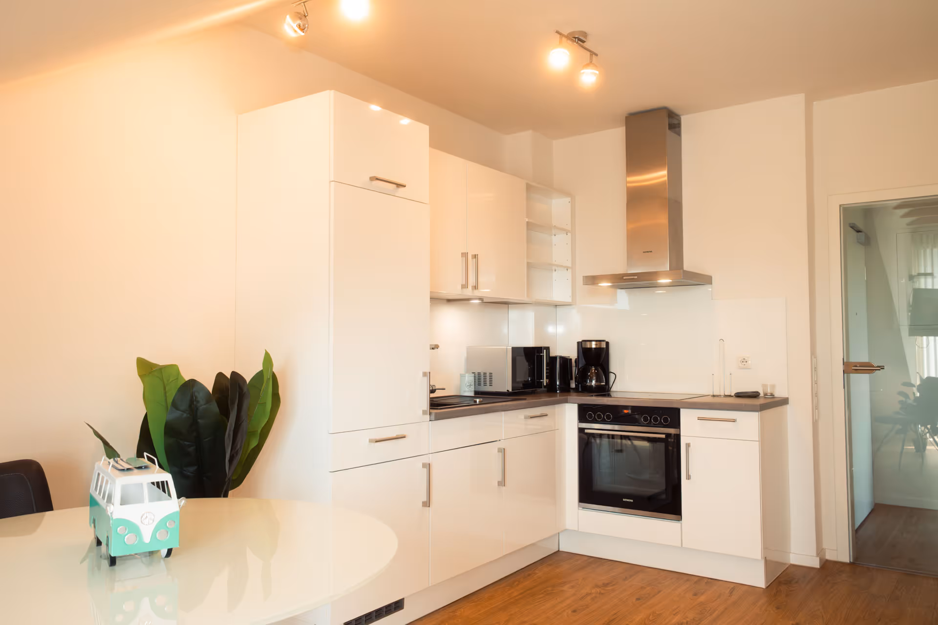 Moderne Kueche mit weißen Fronten und Geraeten