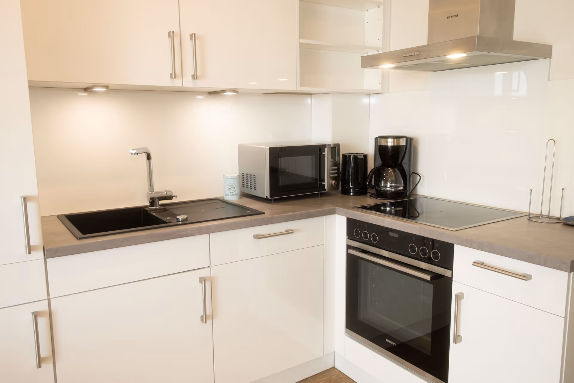 Kuechenspuele und Elektrogeraete auf grauer Arbeitsplatte