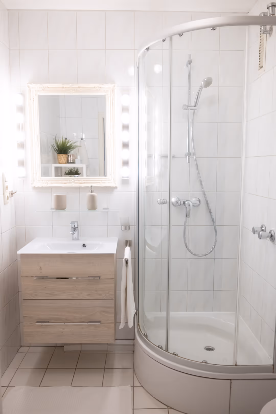 Badezimmer mit Dusche und Spiegelleuchte