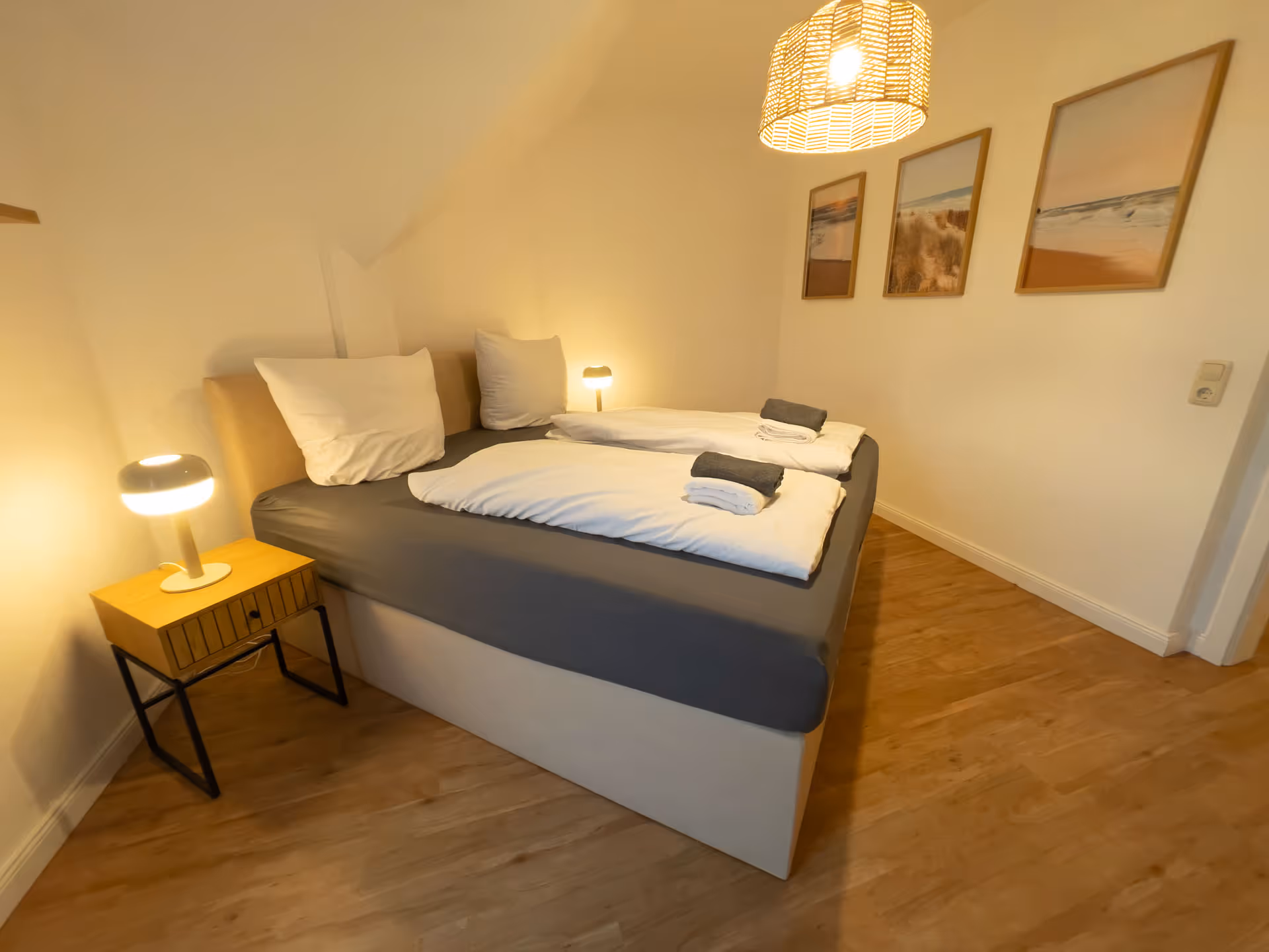 Schlafzimmer mit Doppelbett und Wandbildern