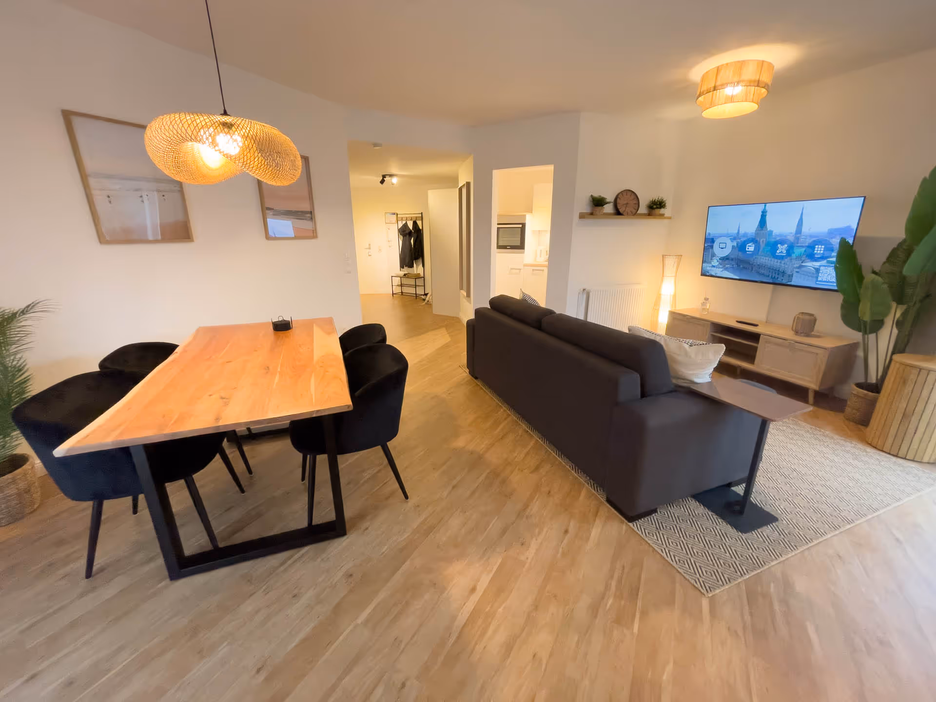 Wohnzimmer mit Sofa, TV und Haengelampe