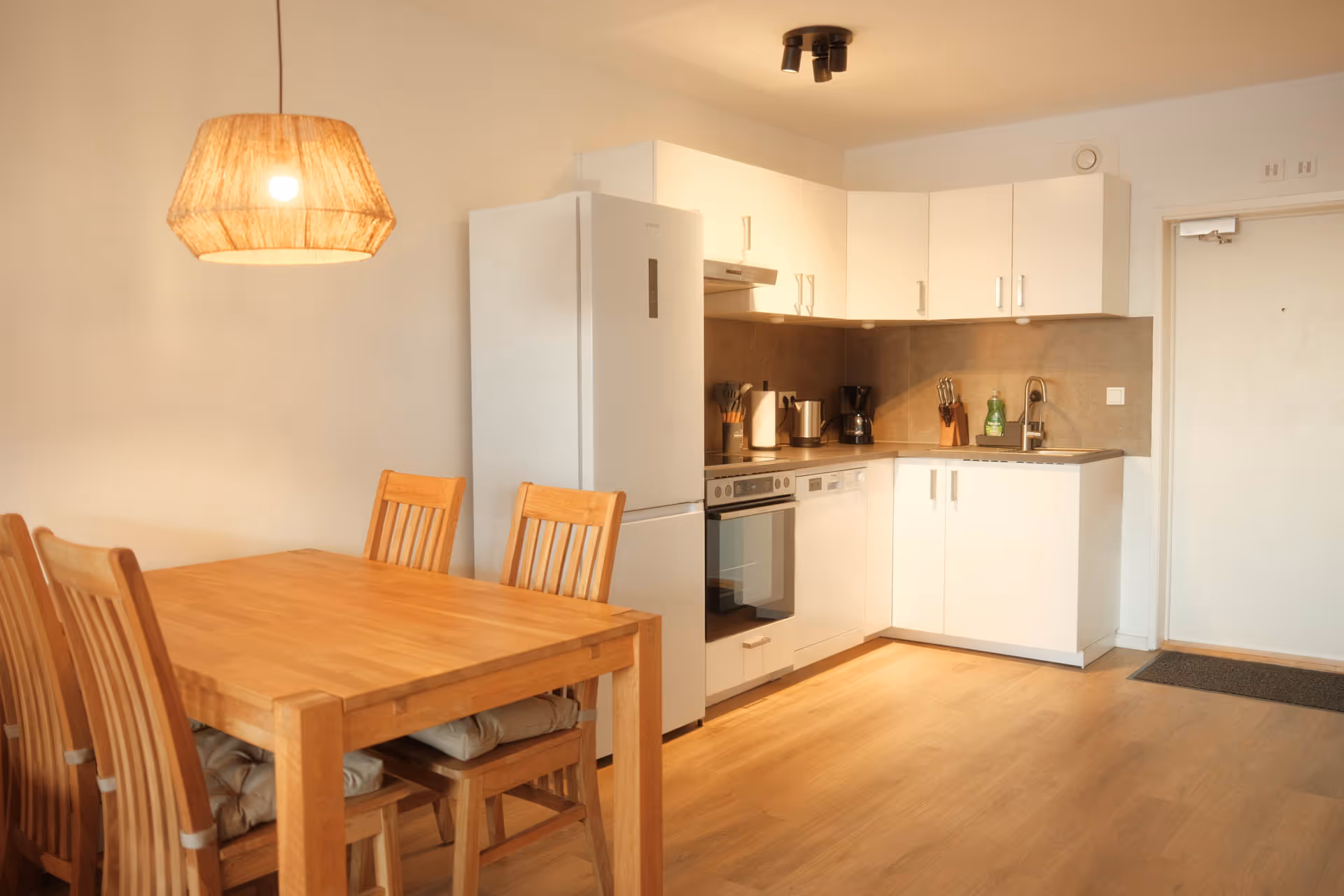 Essbereich aus Holzesstisch neben moderner Kueche