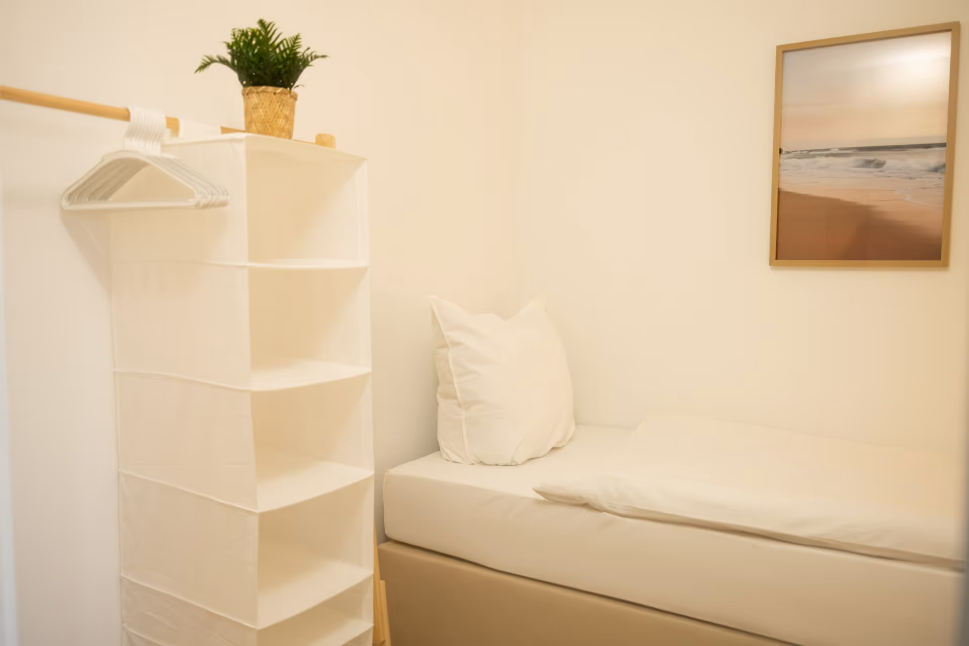 Einzelbett mit Wandregal und Strandbild