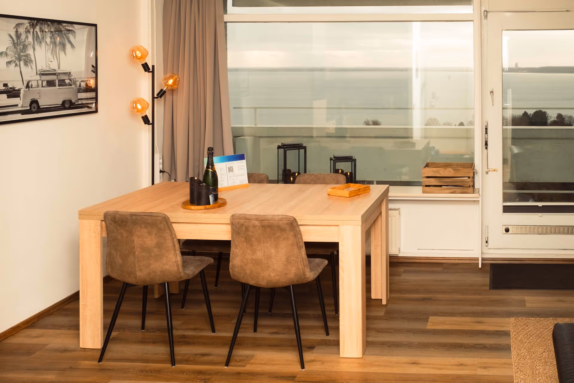 Essbereich mit gemuetlichem Licht mit Blick auf den Balkon und Meer