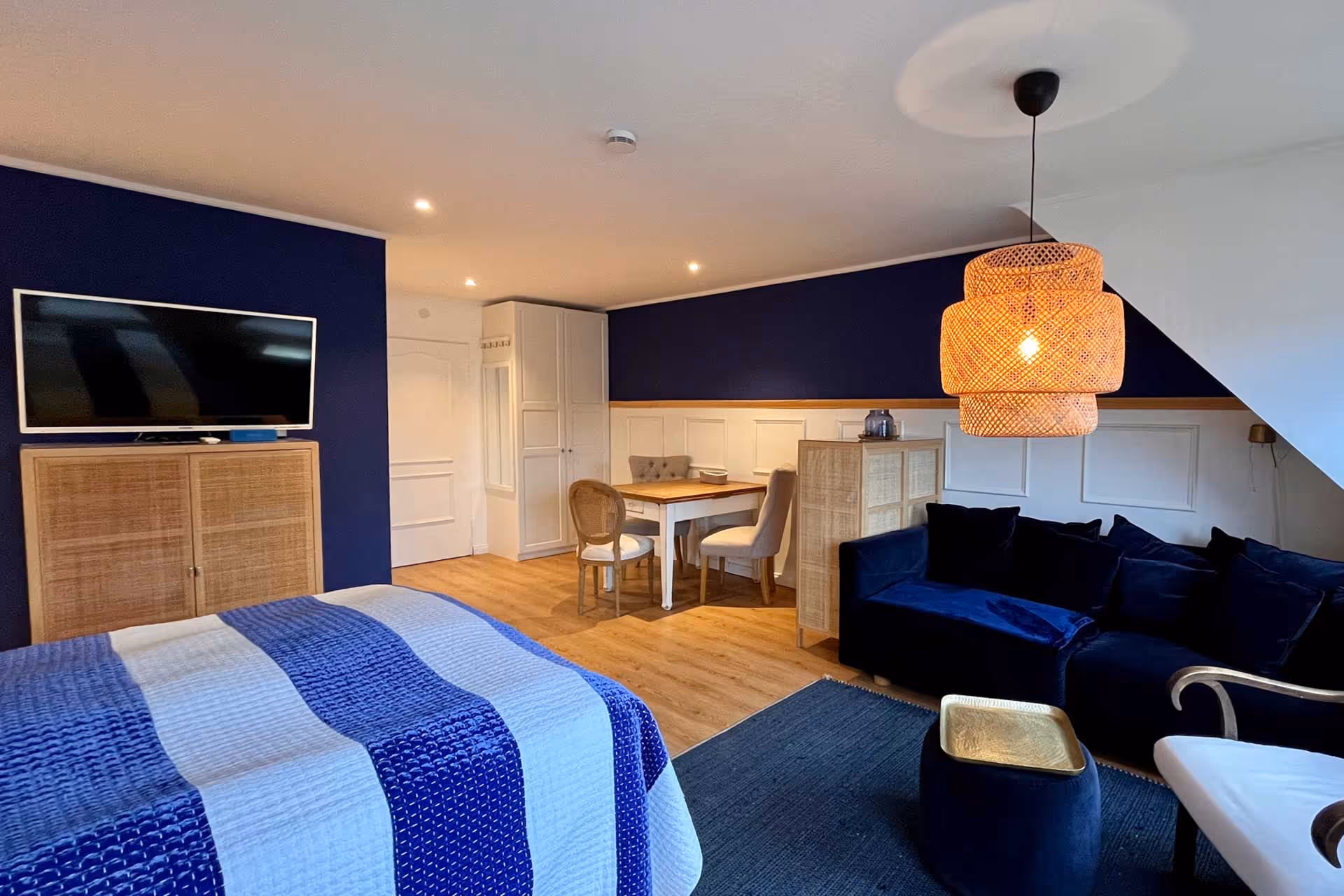 Wohnbereich mit Sofa, Esstisch und TV