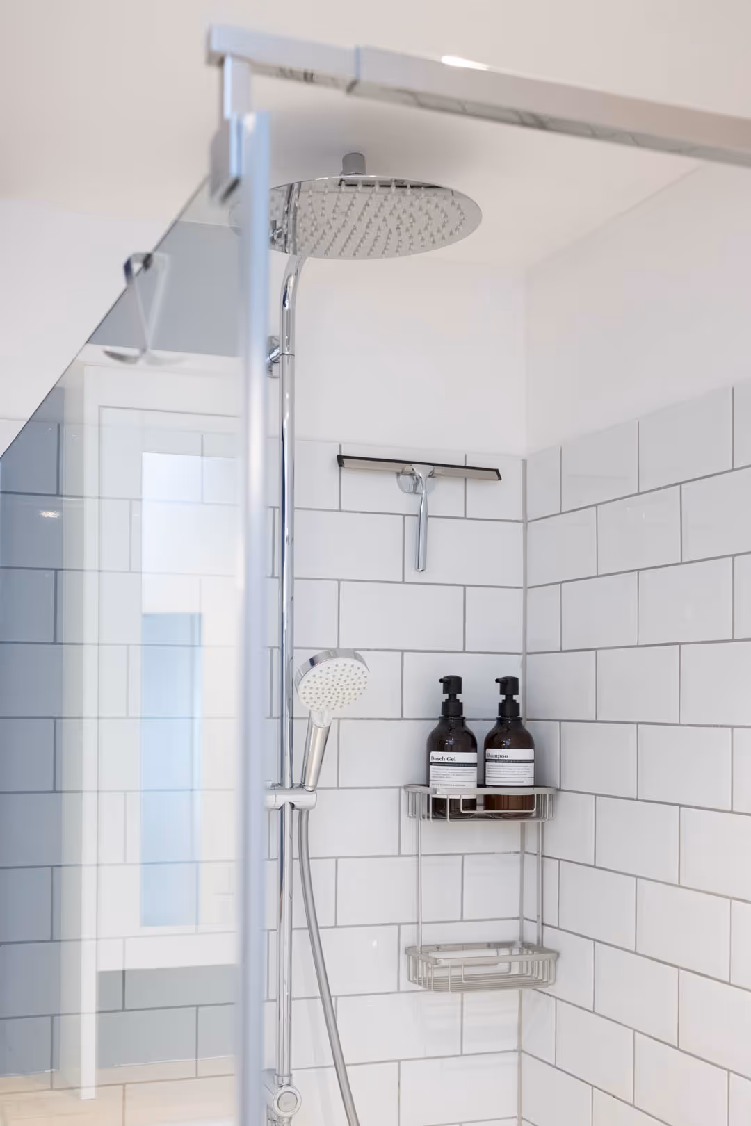 Duschgel und Shampoo in moderner Glasdusche