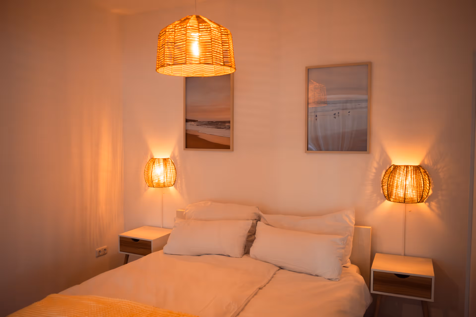 Doppelbett mit Nachttischen und Wandbildern