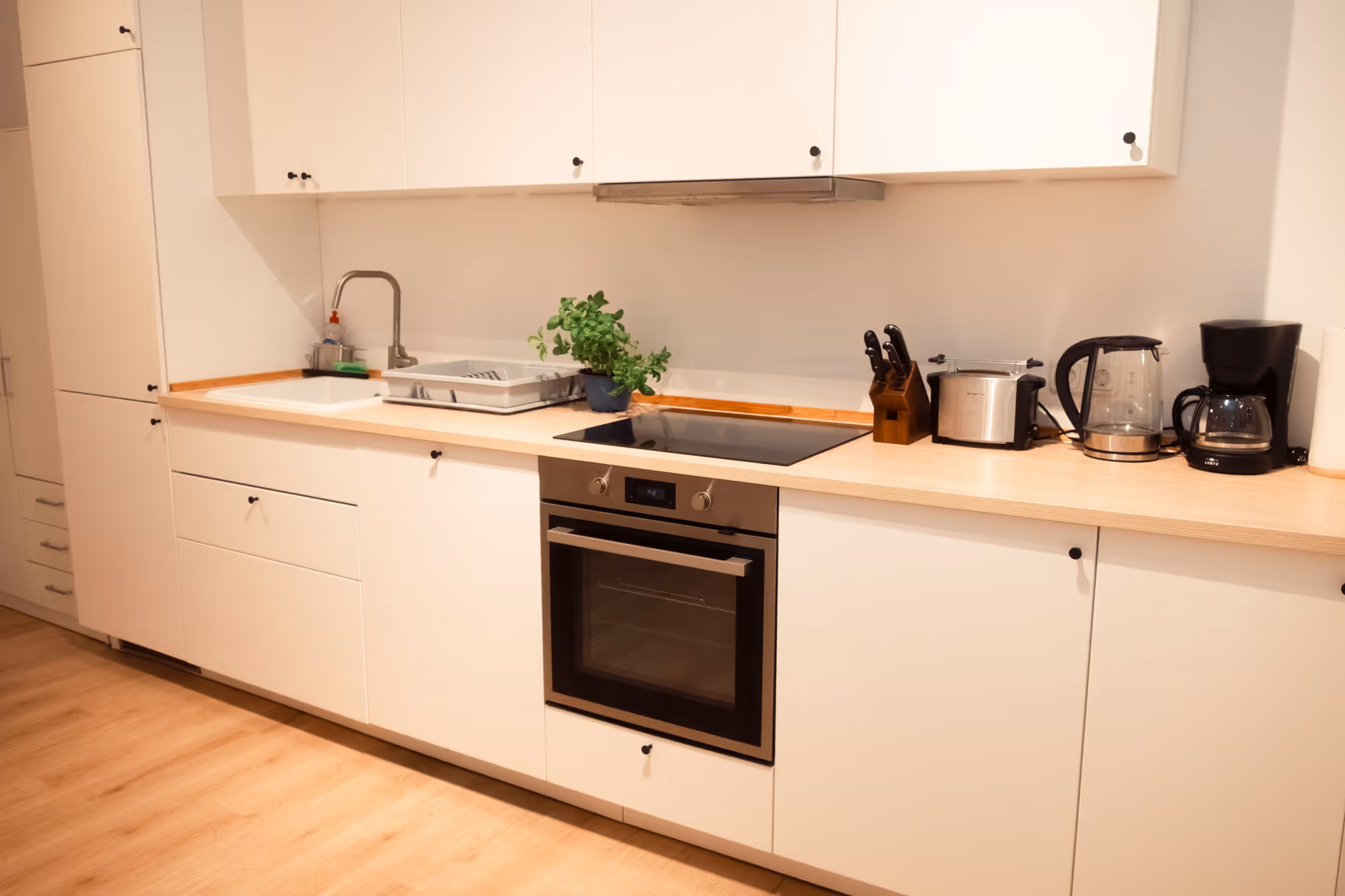 Weiße Kuechenzeile mit Elektrogeraeten