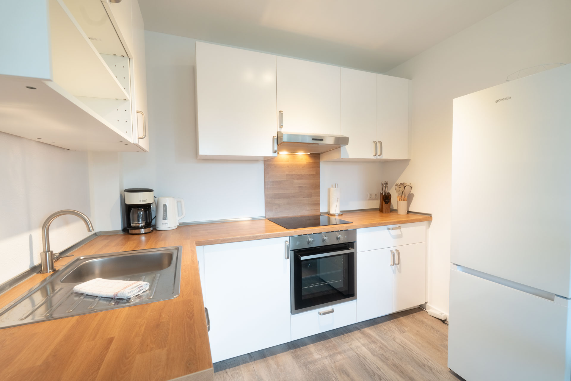 Moderne Vollausgestatte Küche mit Holzarbeitsplatte und großem Kühlschrank