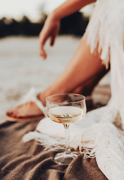A glass of Sauvignon Blanc being enjoyed at the beach.