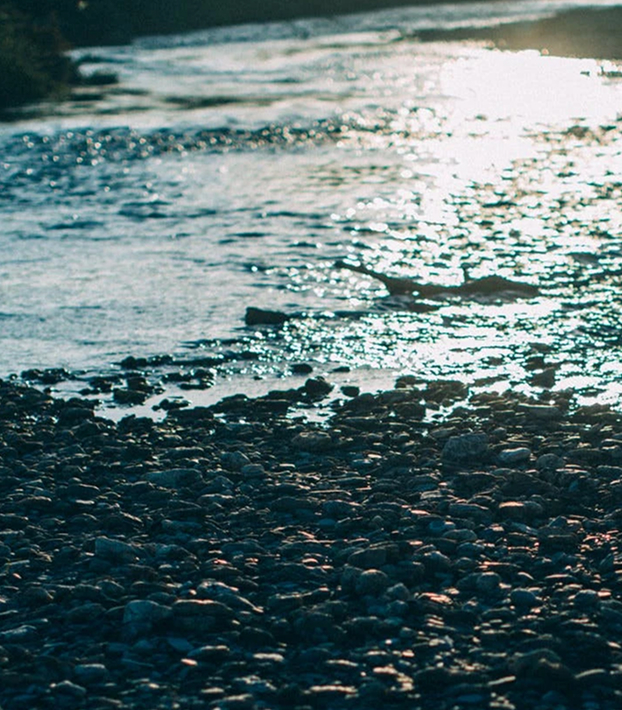 A close up of sun reflecting off the cool stream of water on the river banks.