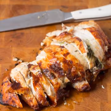 Sliced turkey breast roast on cutting board with knife