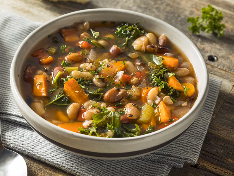 Slow Cooker Southern Mixed Beans with Collards & Sweet Potatoes in a white bowl.