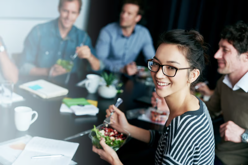 A young woman eating lunch at work.