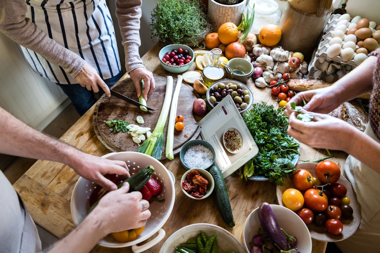 A senior multi-racial couple cooking together using the app.
