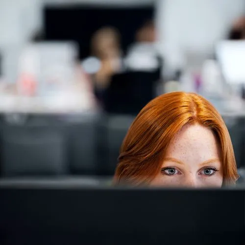 Professional woman focused on computer screen in office, symbolising Wileo’s problem-solving and technology consulting expertise