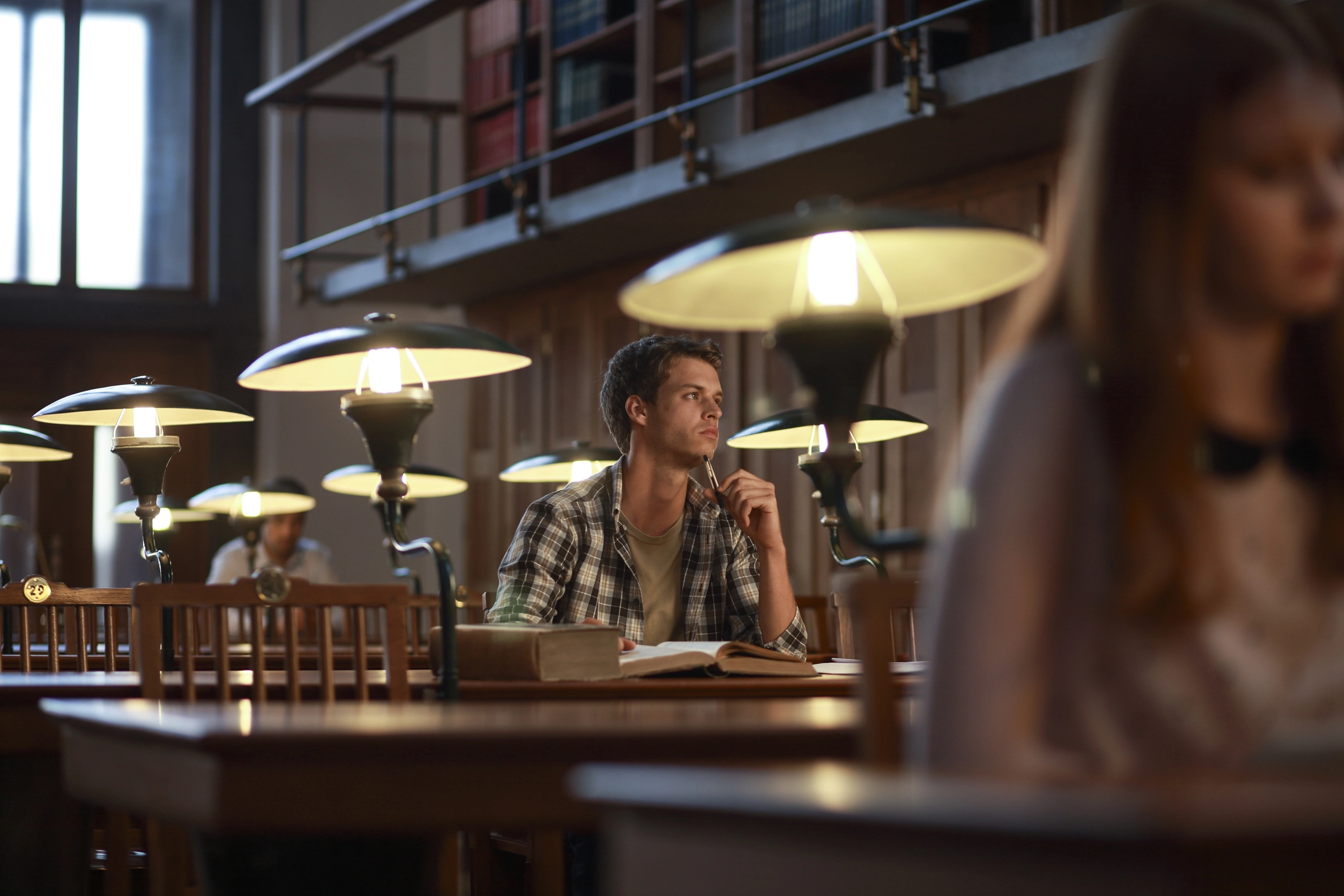 A man deep in thought in a reading room at a library.