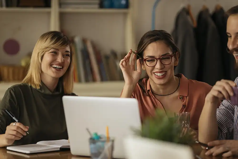 Three workmates sharing a launch while collaborating together.