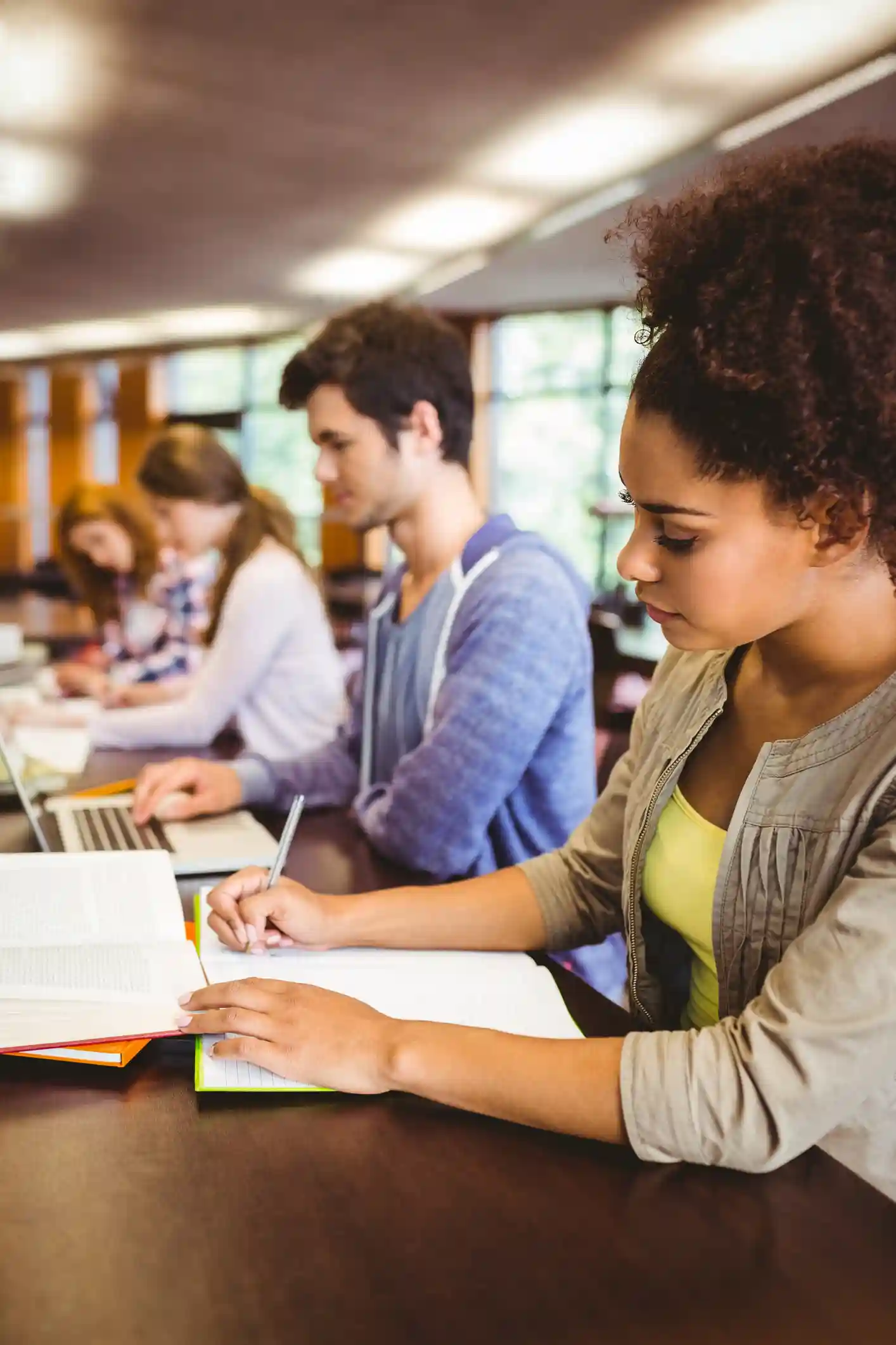 Post-secondary students studying individually in a library.