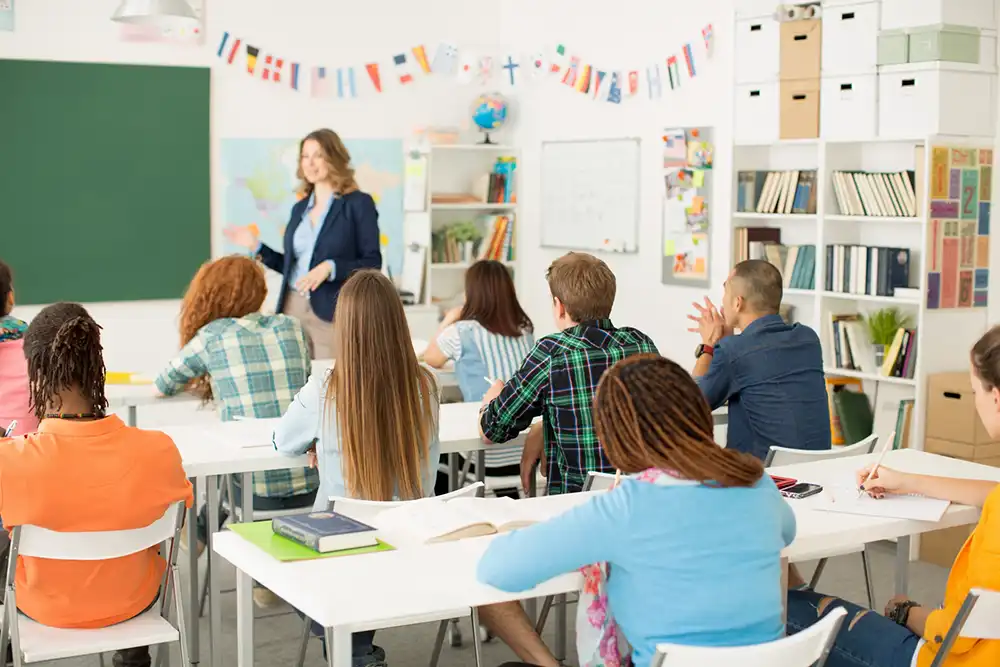 A teacher teaching in a classroom to attentive students.