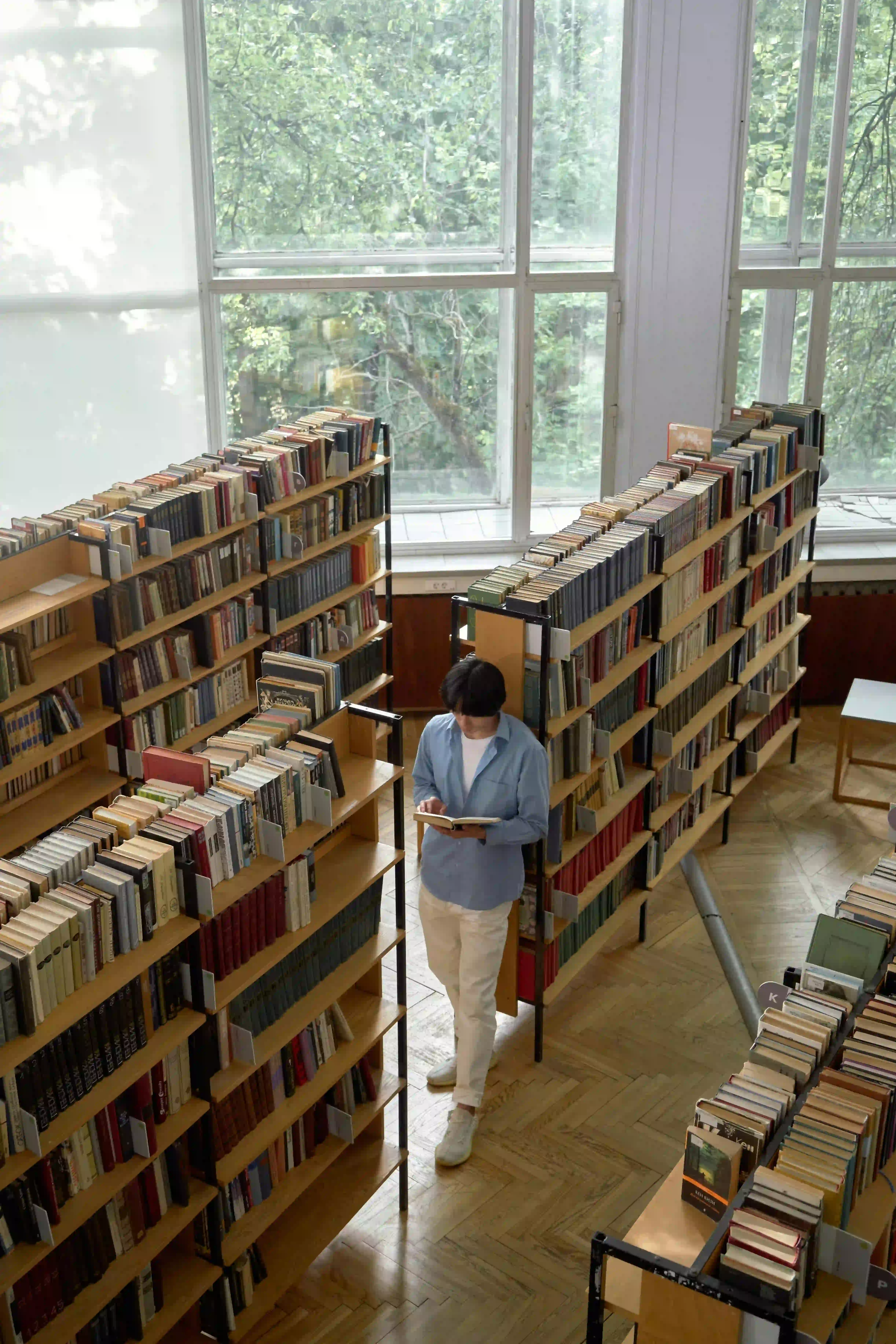 A student reading a book at a post-secondary library.