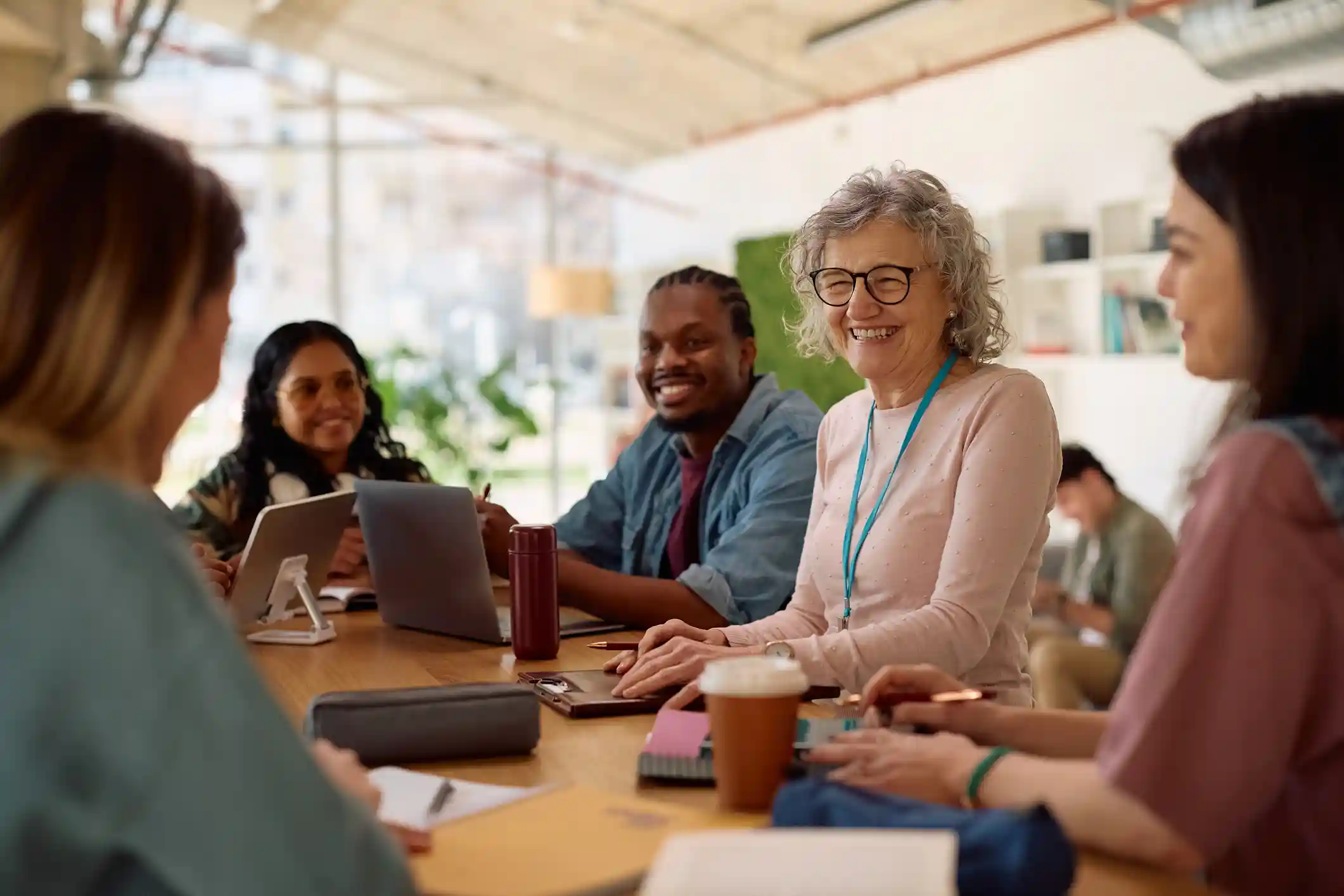 A group of mature students smiling while studying together.
