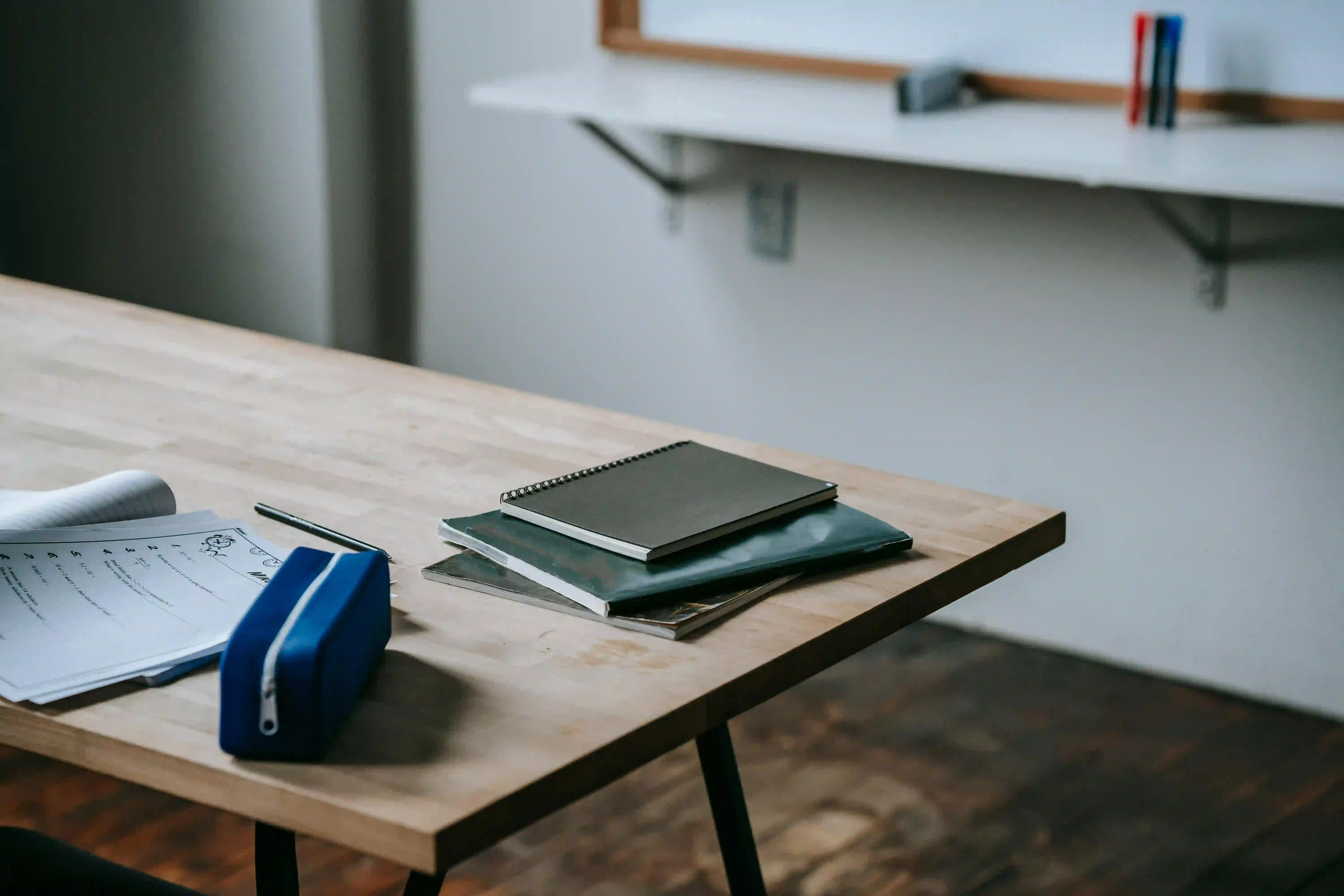 A notebook and other printed materials on a wooden table.
