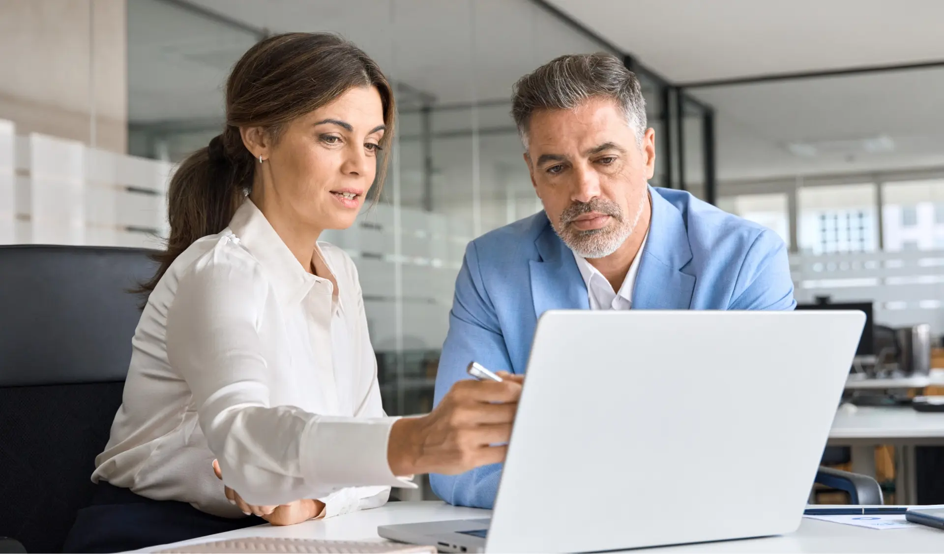 Two business colleagues collaborating together on a laptop.