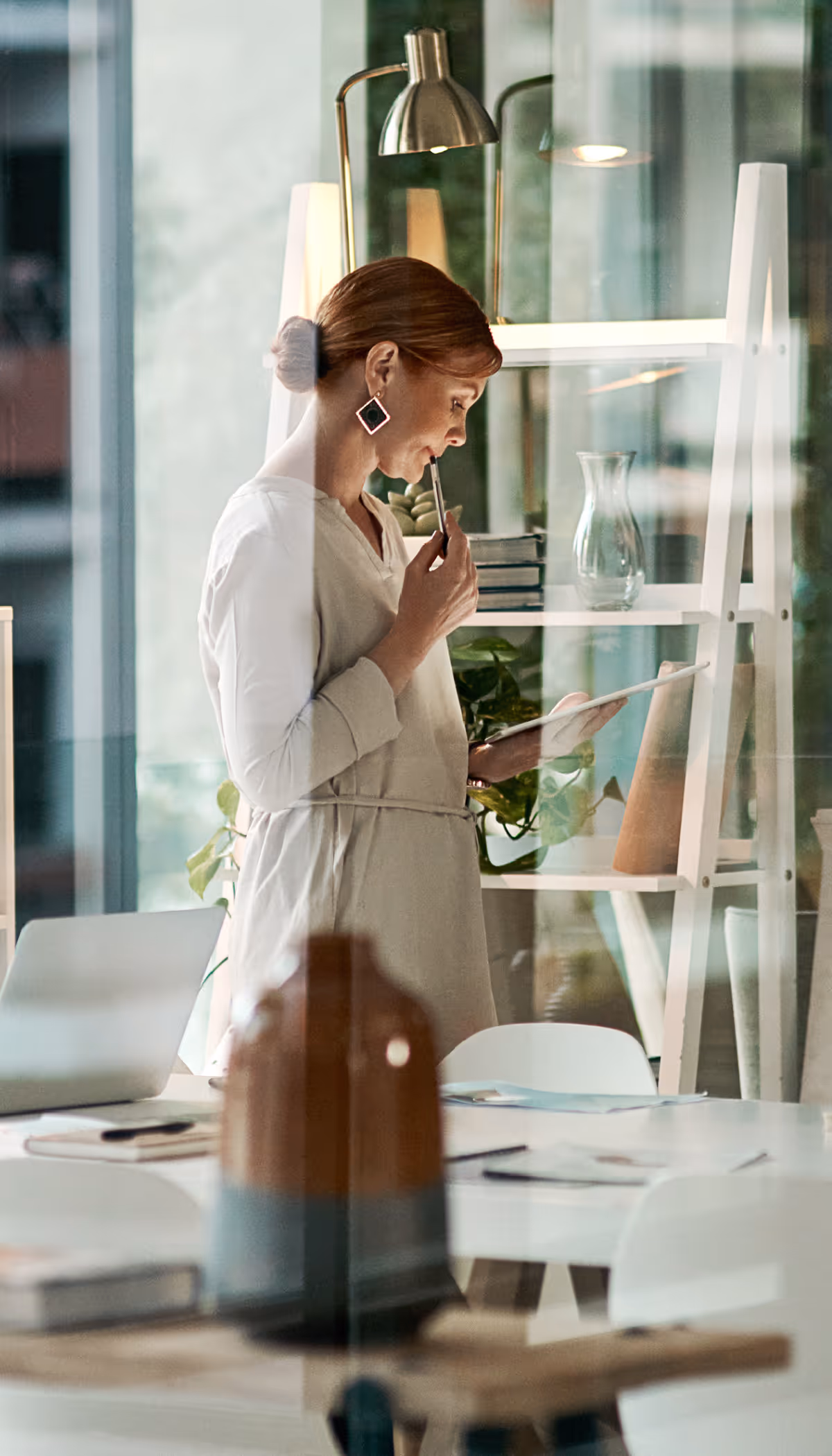 Stockimage of a women holding a tables and looking at it.