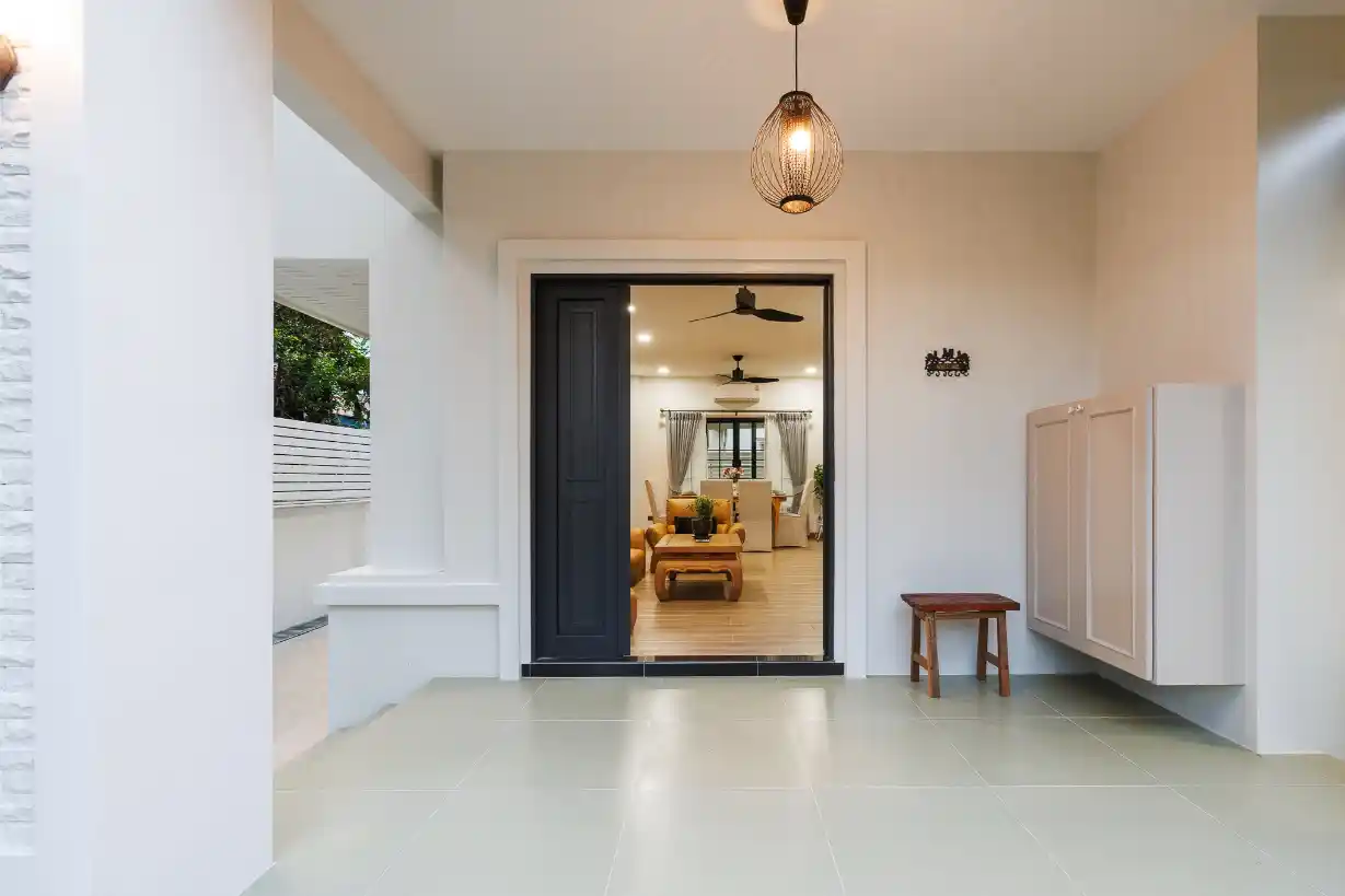 View from the modern tiled porch looking through the open door into the bright living room.