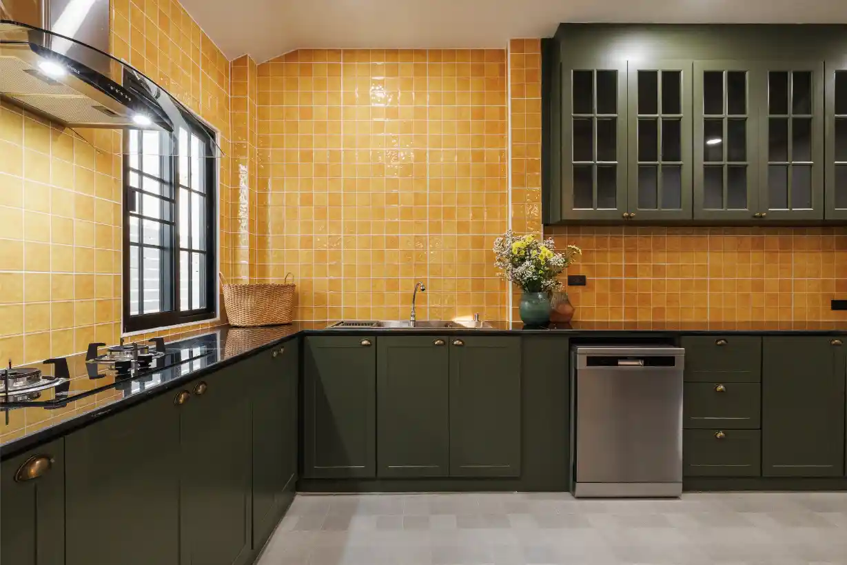 Modern European-style kitchen with dark green cabinets, yellow tile, and a dishwasher