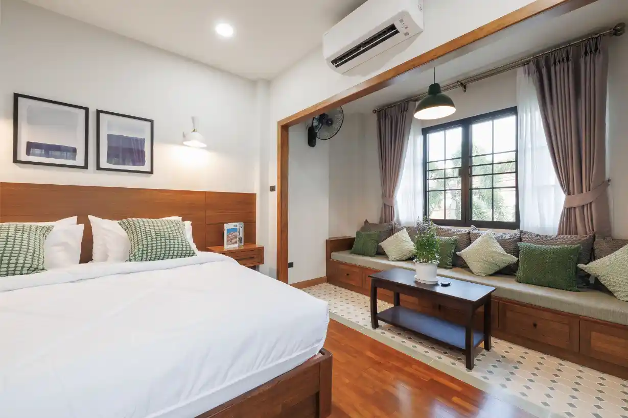 Spacious primary bedroom with a tufted headboard, sitting area, and a separate vanity desk.