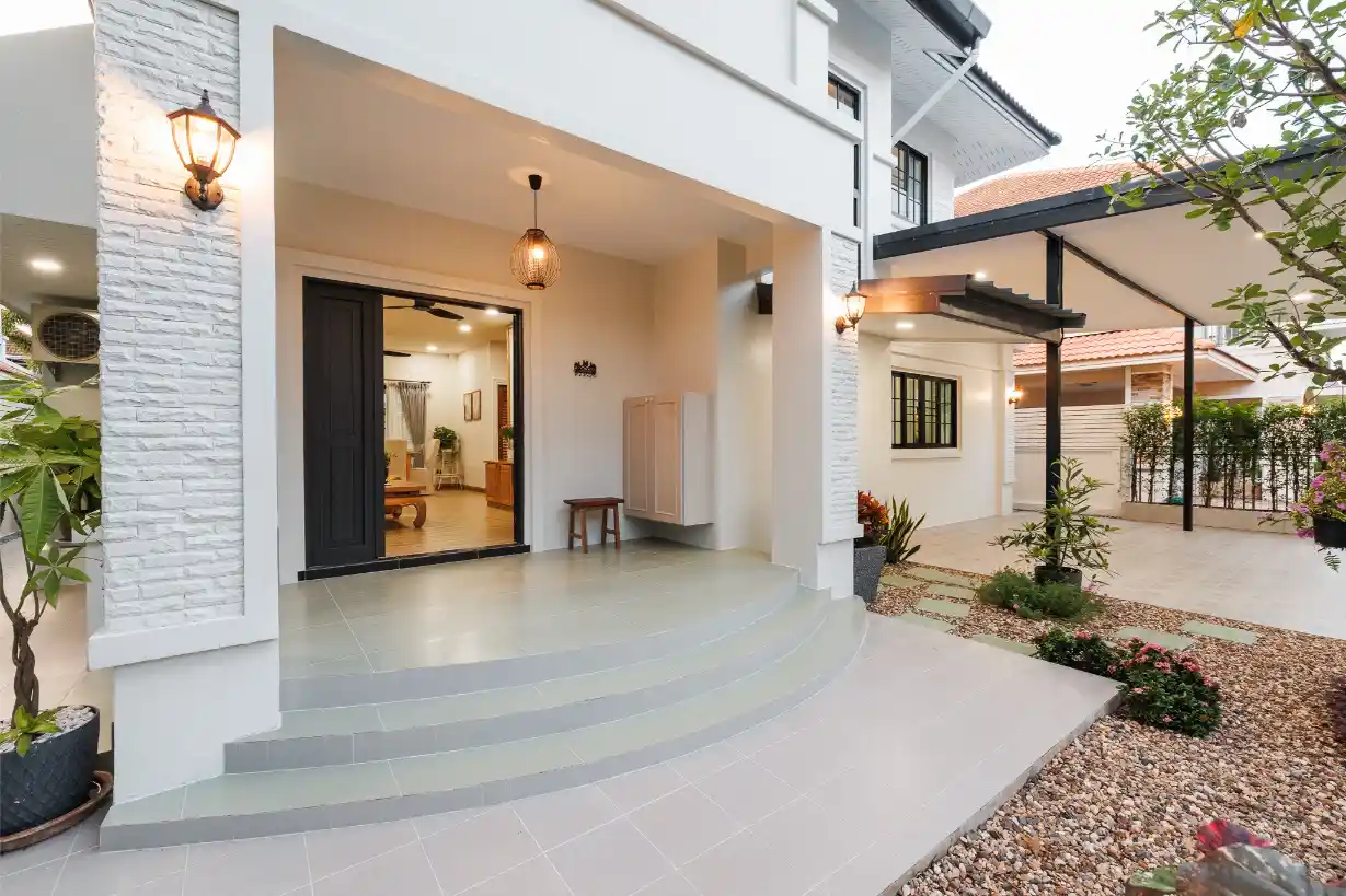 The main entrance with curved steps and a covered porch, showing a view into the living room.