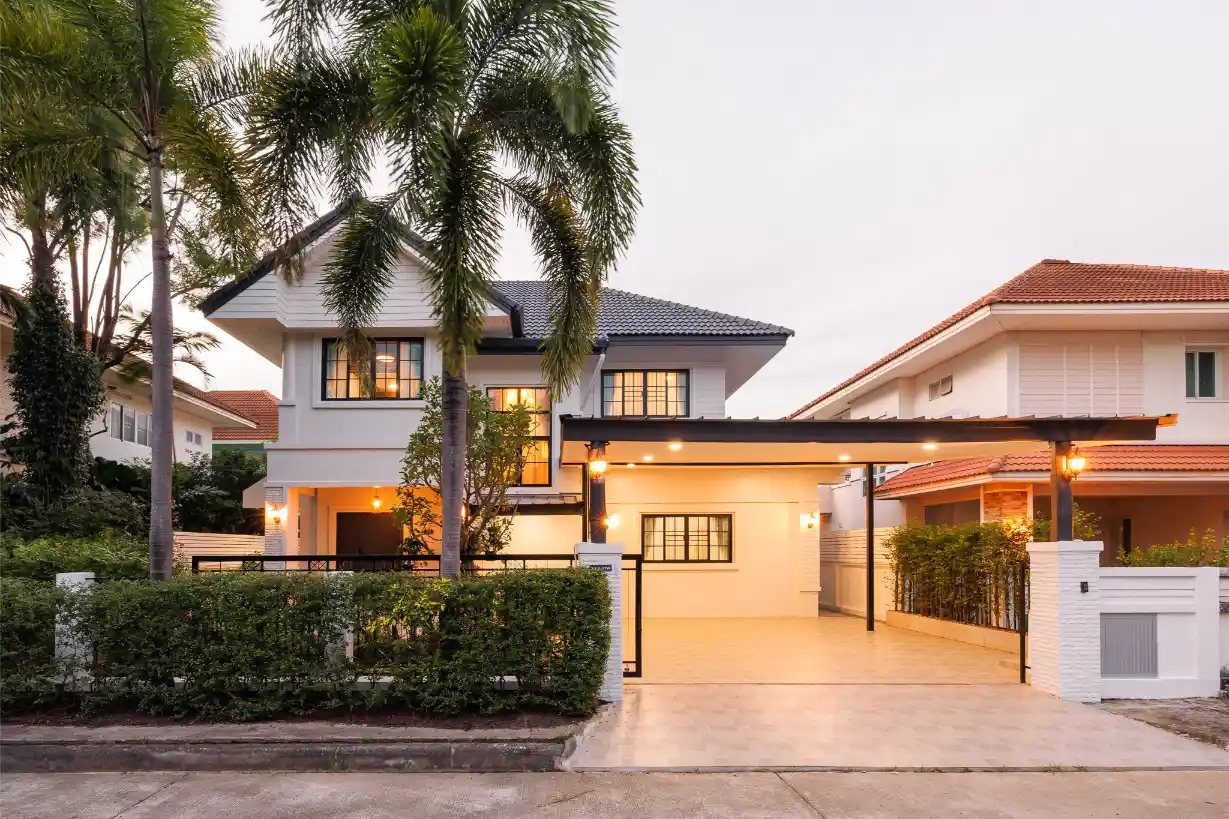 Modern 2-story home in San Sai at dusk with a lighted carport and secure gated entrance.