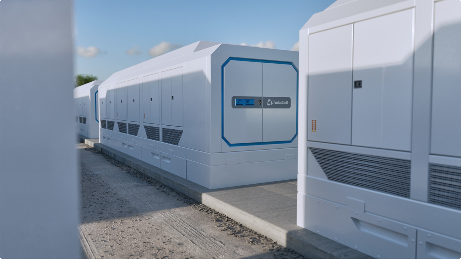 Row of large white industrial battery storage units labeled 'TurboCell' under a partly cloudy sky.