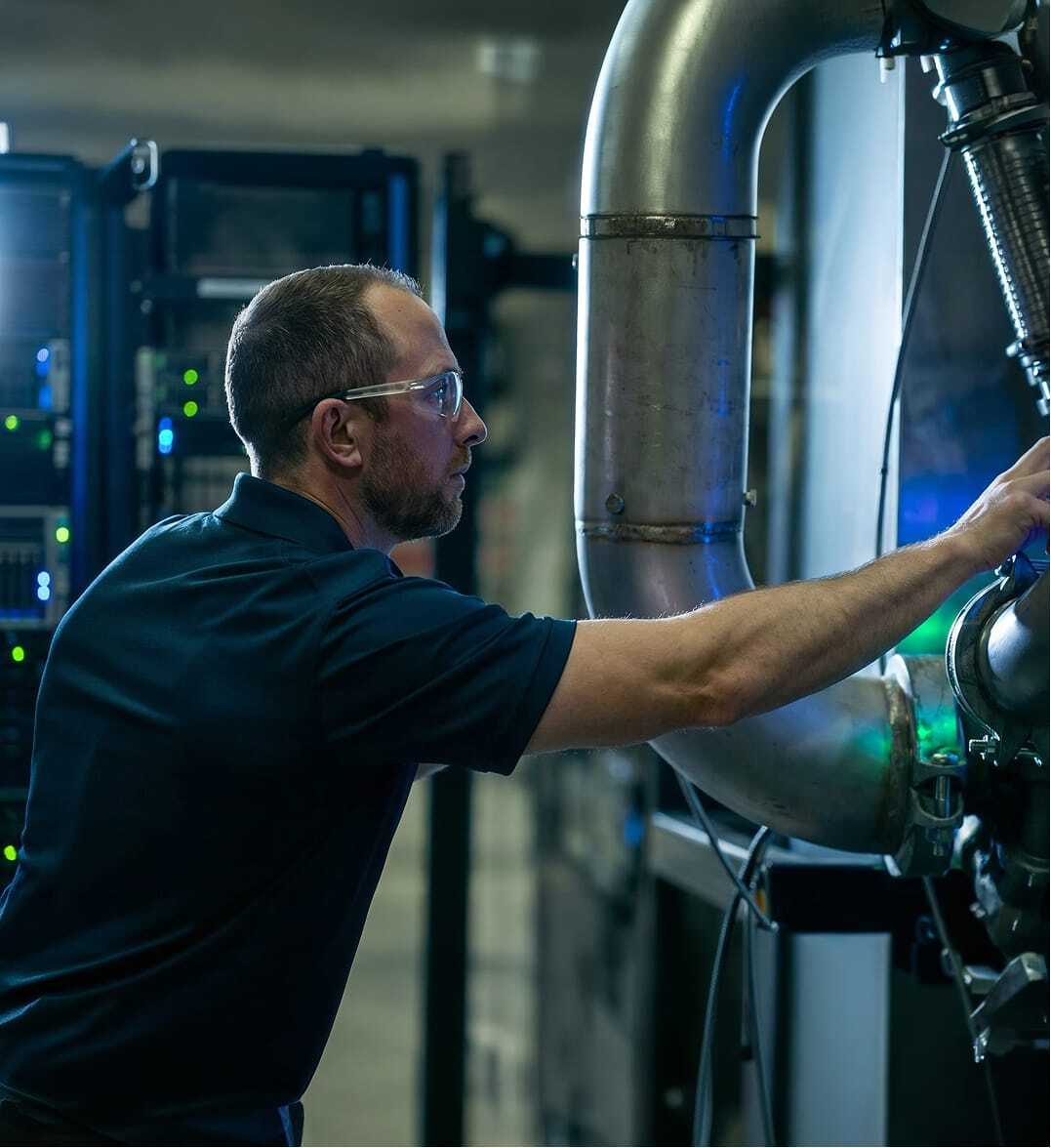Long corridor of server racks illuminated with blue LED lights inside a modern data center.