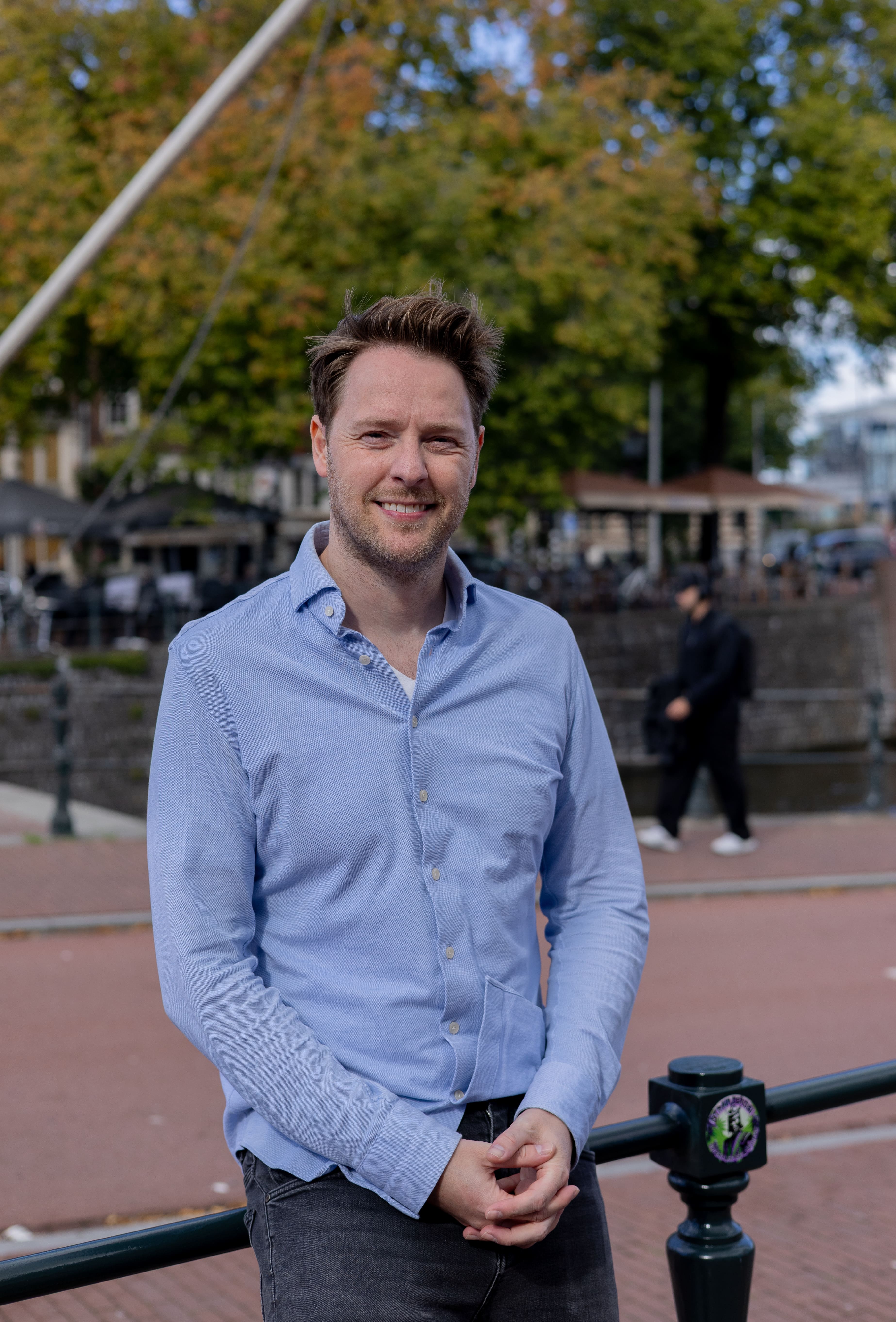 Vincent Carree, eigenaar Groeileaders, staat voor een hek aan de Amsterdamse gracht.