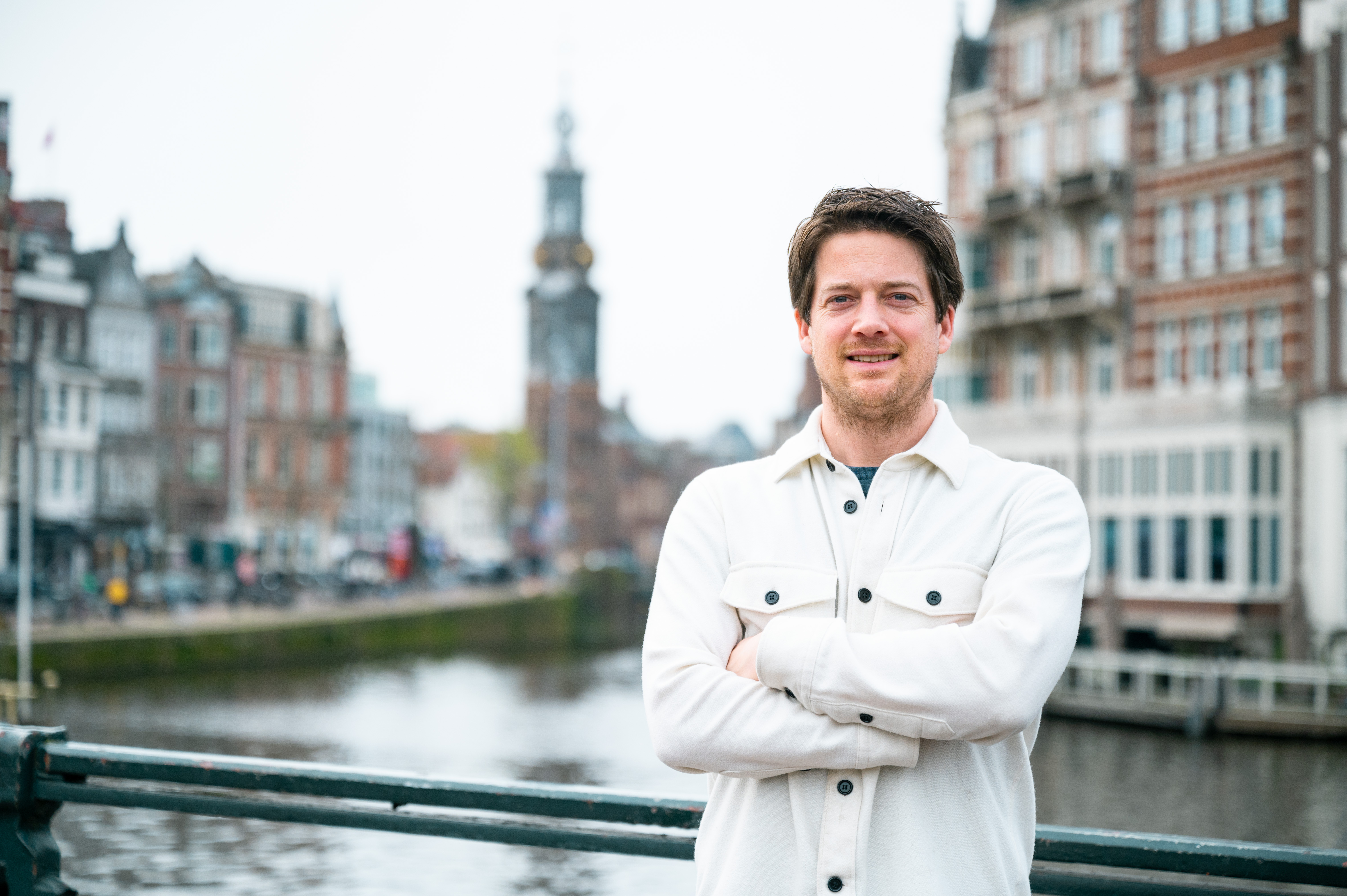 Man staat lachend op een brug