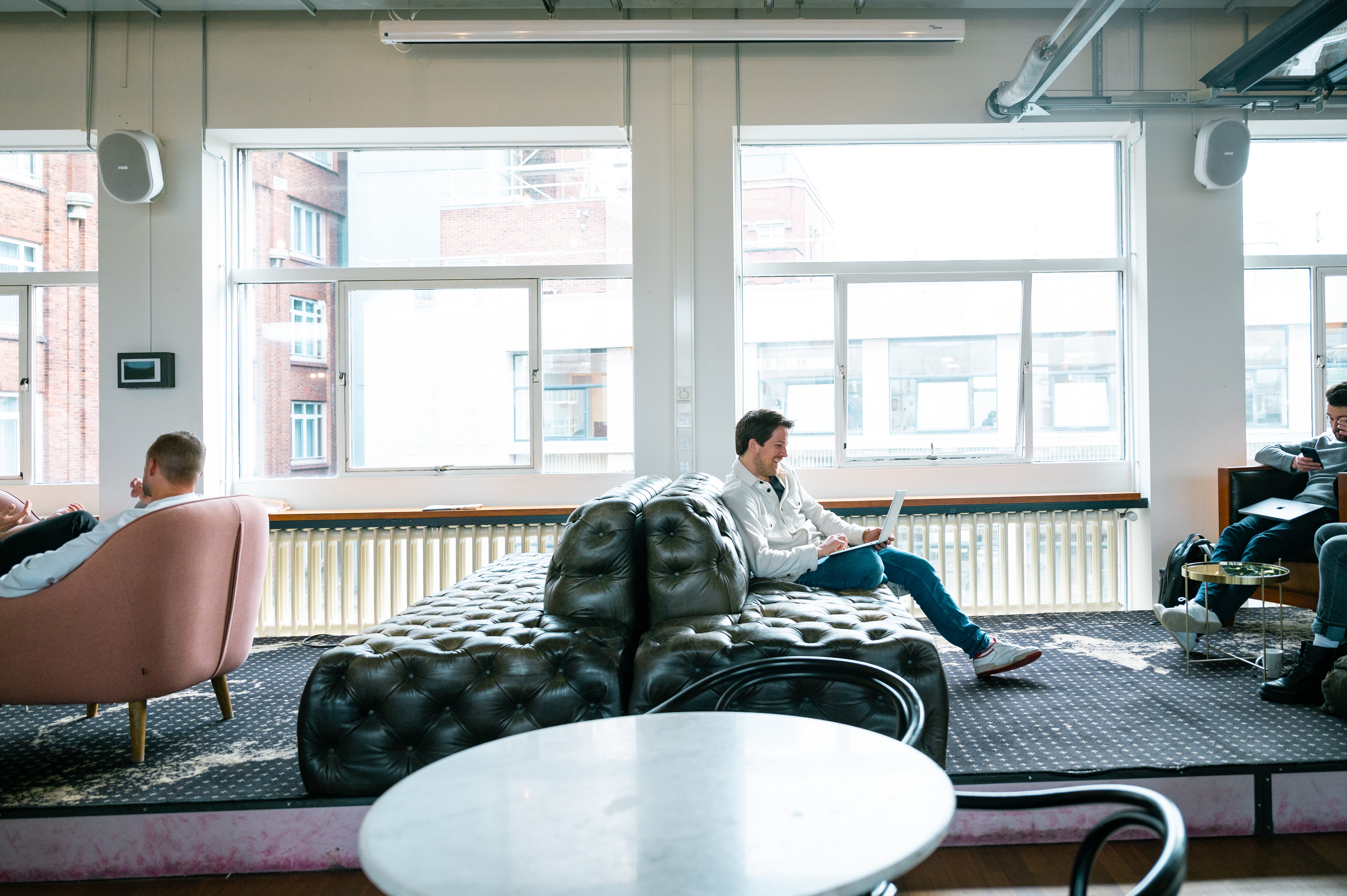 Man met laptop zit op bank