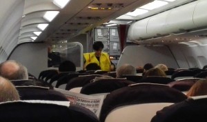 Une hôtesse présente les gilets de sauvetage lors du briefing de sécurité de début de vol