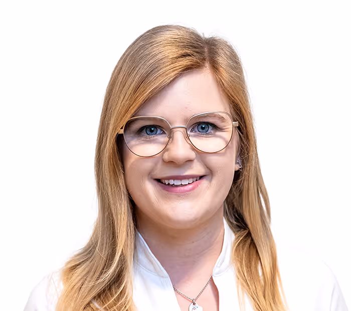 Junge Frau mit langen blonden Haaren, Brille und weißer Bluse vor weißem Hintergrund.