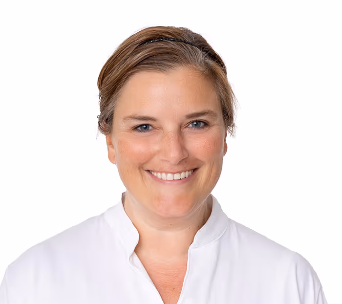 Porträt einer lächelnden Frau mit braunem Haar und weißer Bluse vor weißem Hintergrund.