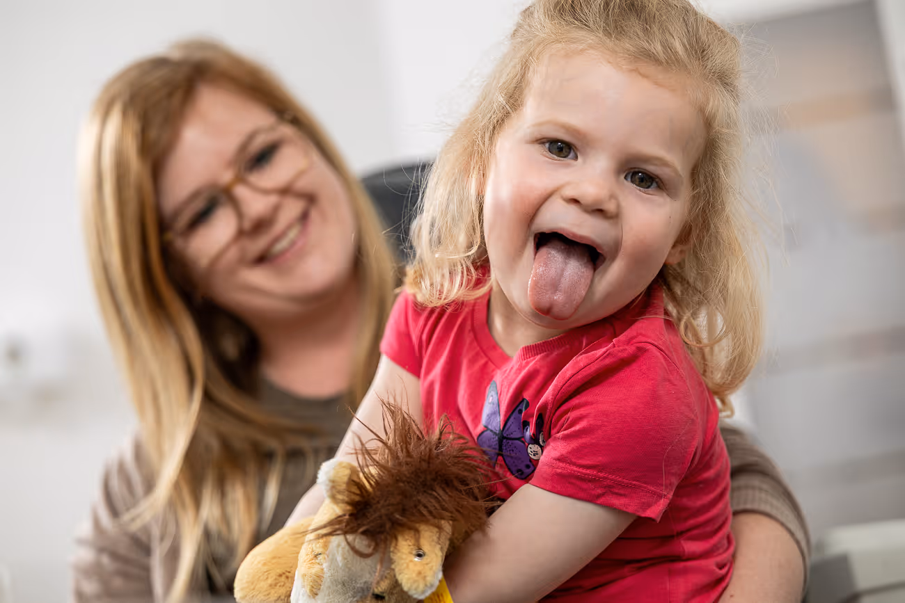 Patientenkind strckt kess die Zunge raus und freut sich