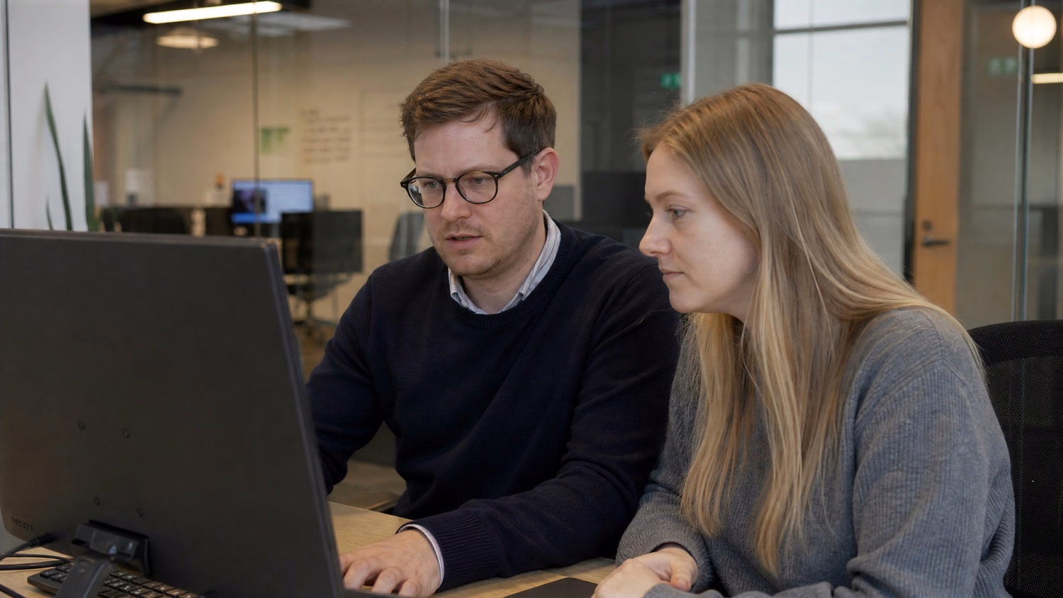 SIDE-BY-SIDE PAIR An IT professional two people seated side by side reviewin