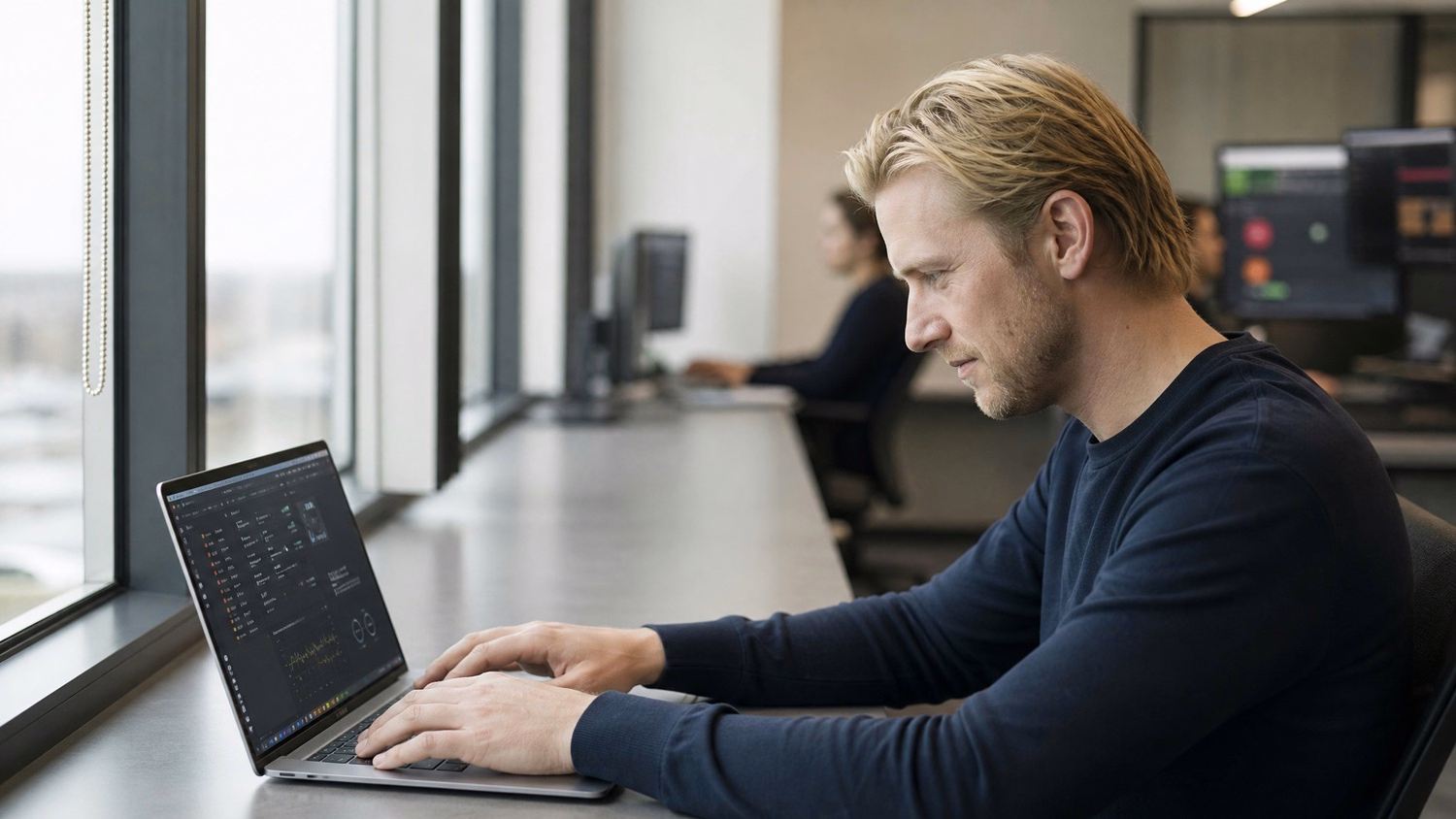 Man at window seat reviews complex IT dashboard
