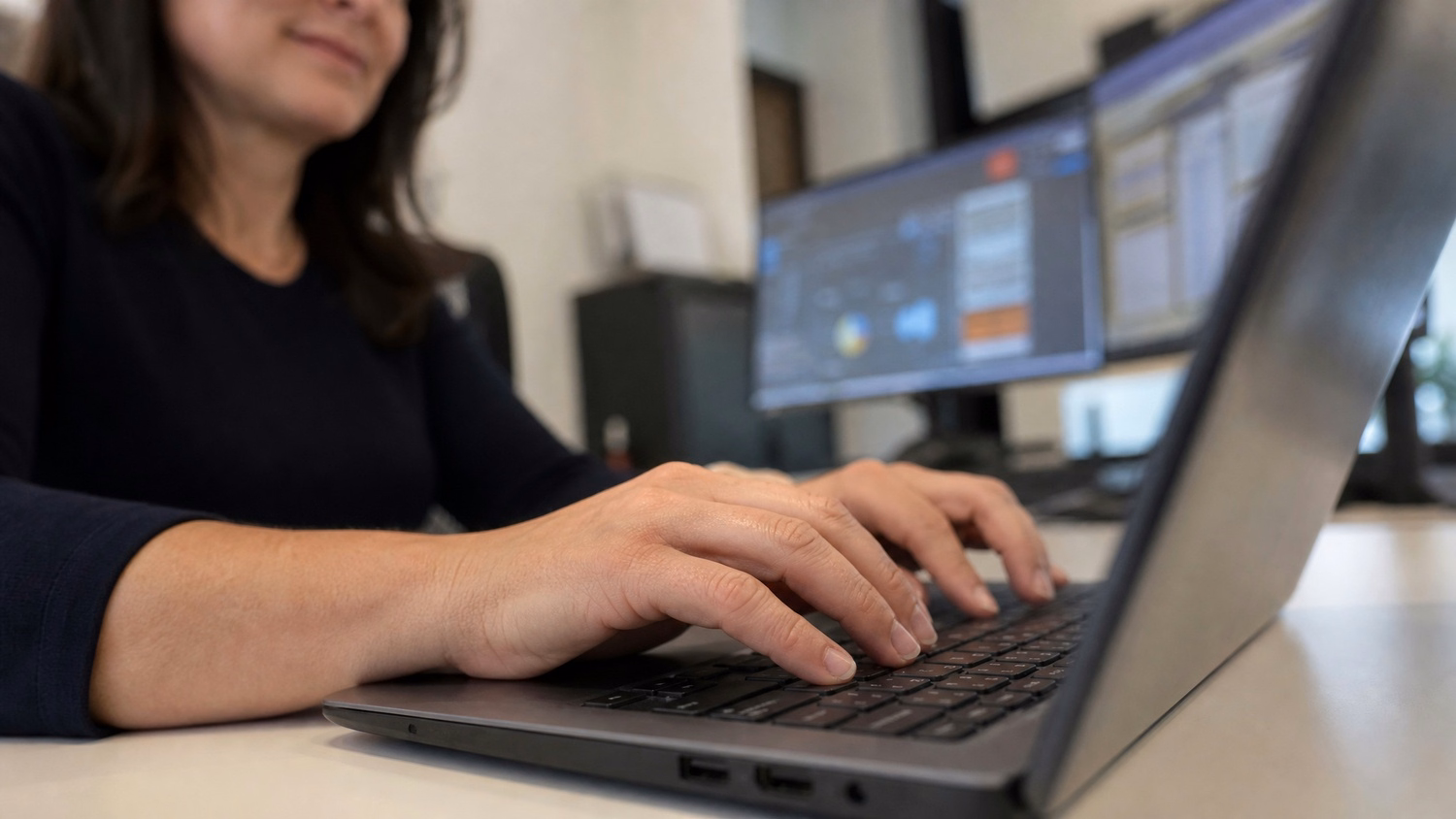 Womans hands typing on laptop keyboard, blurred background 63 chars