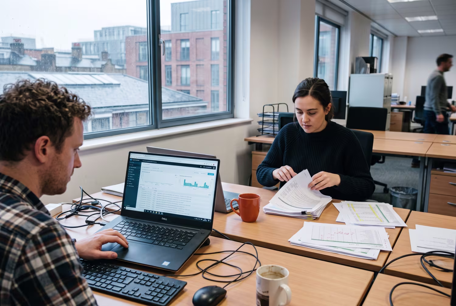 IT professionals reviewing data and organizing printouts in London office