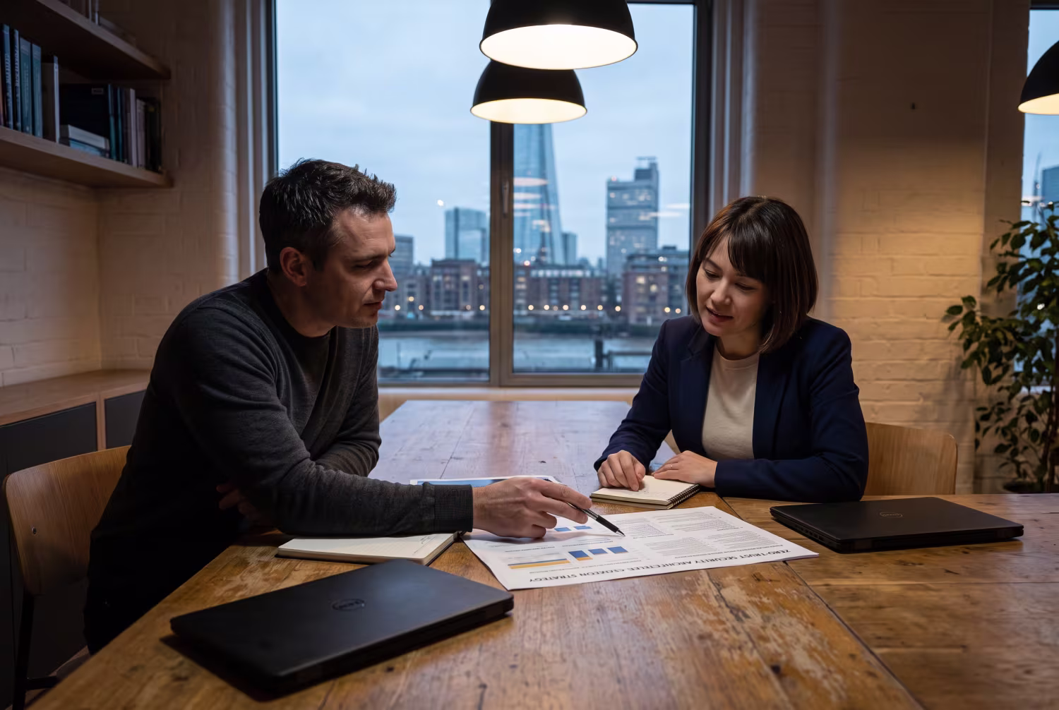Two IT professionals discussing zero-trust security strategy document
